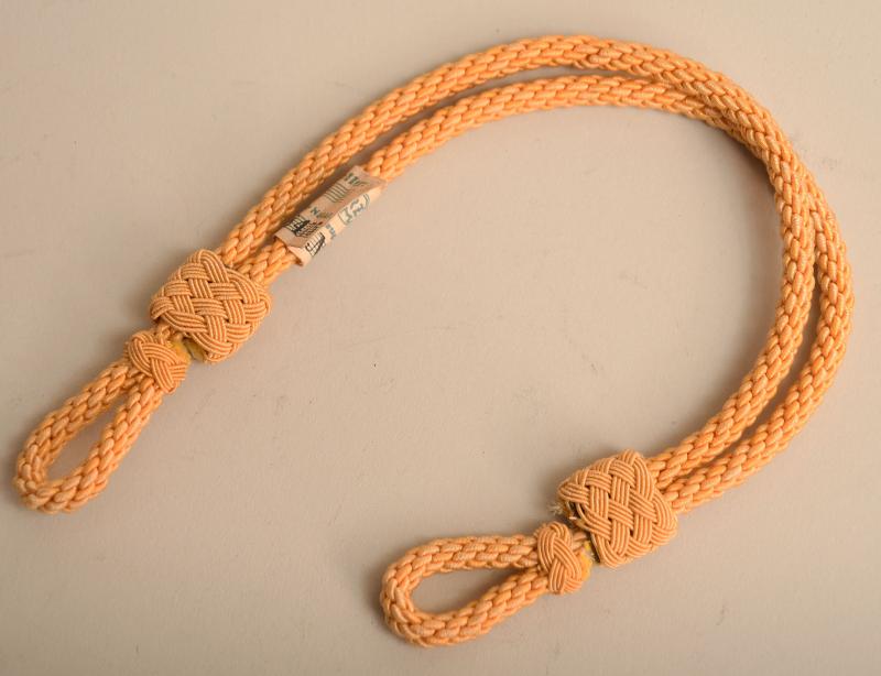 GERMAN WWII POLITICAL CAP CORD WITH PAPER TAG ATTACHED.