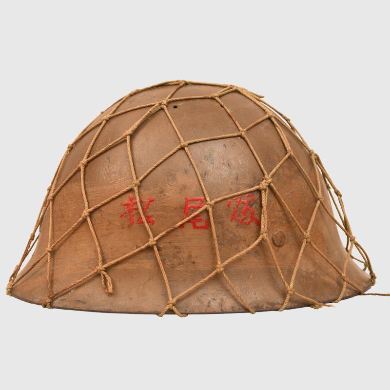 JAPANESE WWII TYPE 90 COMBAT HELMET WITH CAMOUFLAGE NET, IDENTIFIED TO AN INDIVIDUAL SOLDIER.